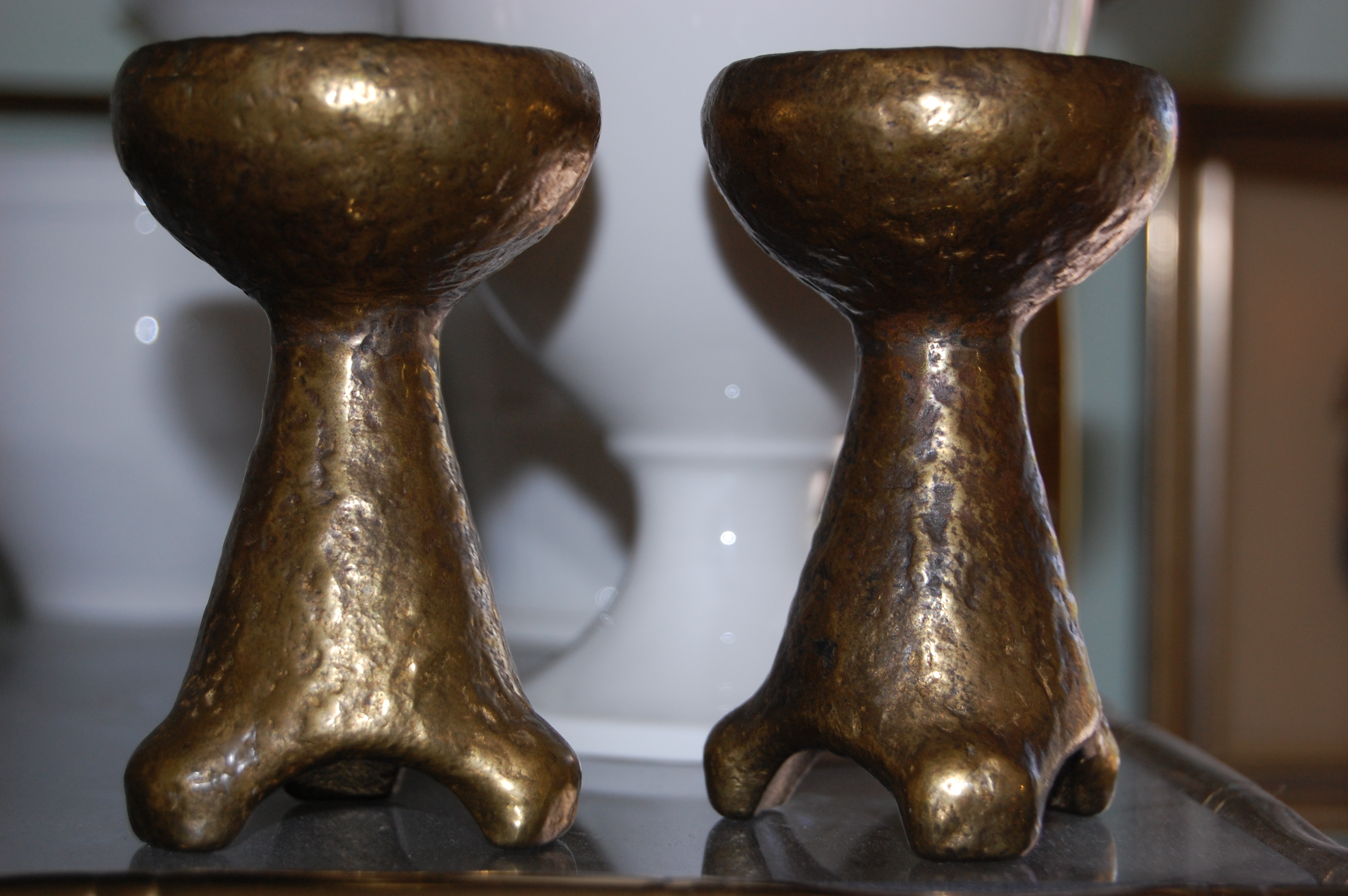 A pair of small brutalist style brass candle holders