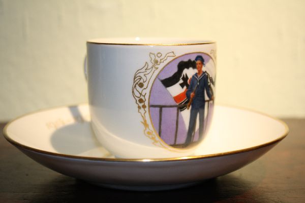 A patriotic porcelain collectable Meissen cup and saucer, sailor in front of the German war flag 